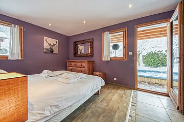A bedroom with purple walls and a deer painting on the wall