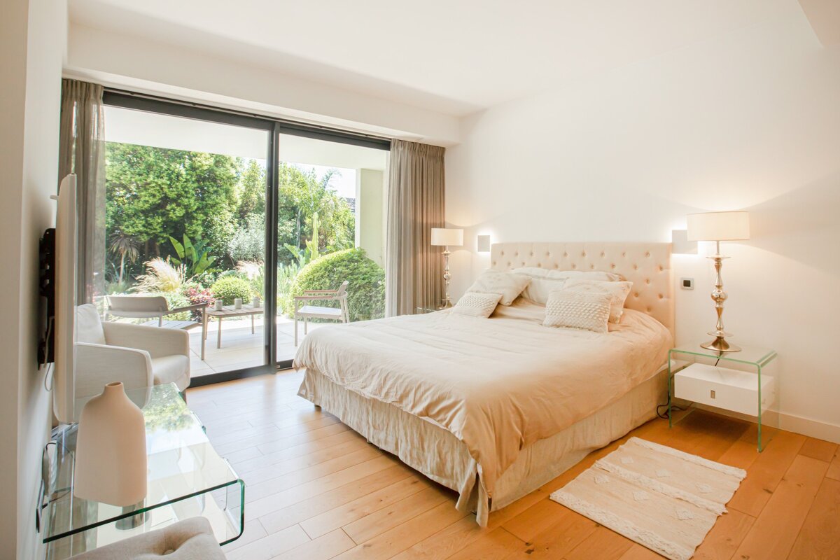 A bedroom with a large bed and a sliding glass door