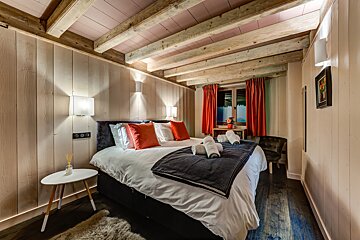 A bedroom with a bed and a small table
