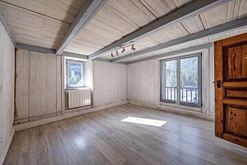 An empty room with a window and a radiator