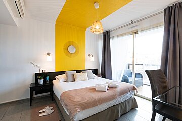 A hotel room with a yellow and white striped wall