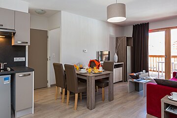 A living room with a dining table and chairs