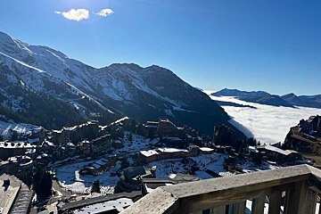 A view of a mountain covered in snow and clouds