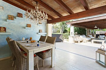 A dining room with a table and chairs and a chandelier