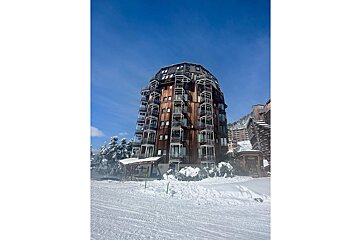 A very tall wooden building with balconies and stairs