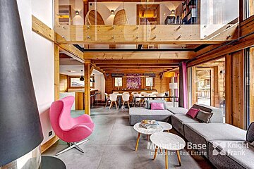 A living room with a pink chair and a sign that says mountain base