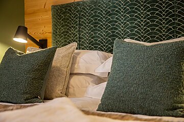 A bed with green pillows and a green headboard