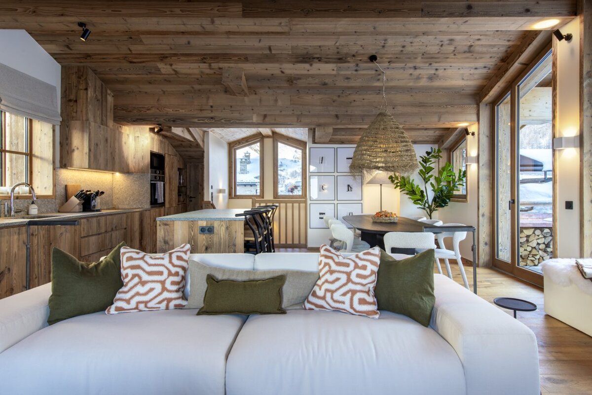 A living room with a white couch and green pillows