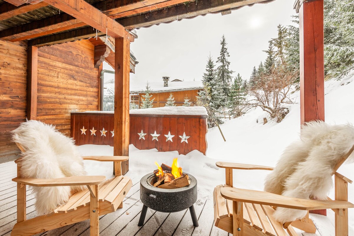 Two wooden chairs sit in front of a hot tub with stars on it