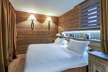A bedroom with a large bed and a walk in shower
