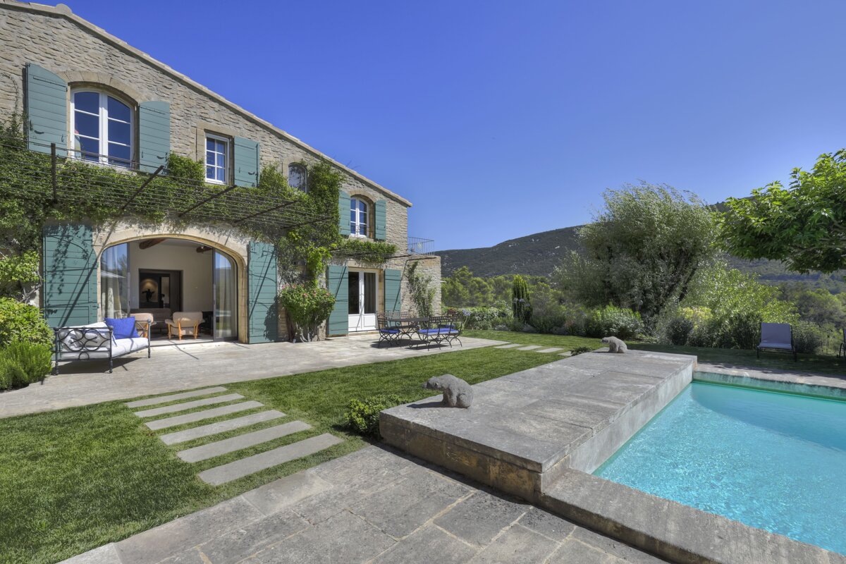 A stone house with a swimming pool in front of it