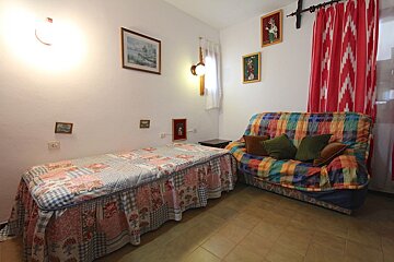 A bedroom with a bed and a colorful couch