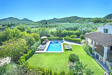 An aerial view of a house with a large swimming pool