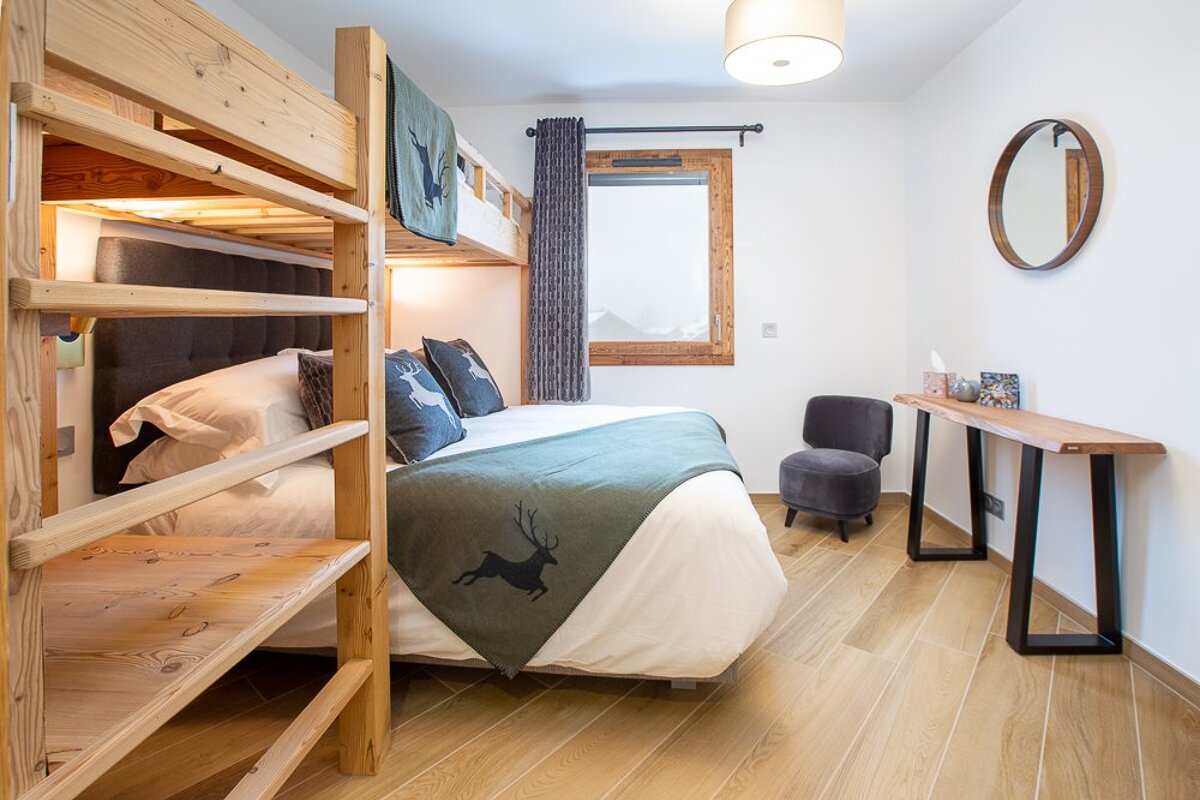 A bedroom with a bunk bed and a mirror