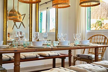A dining room table with plates and glasses on it