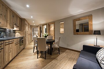 A kitchen with wooden cabinets and a table and chairs