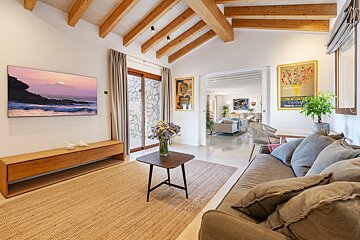 A living room with a couch and a table and a painting on the wall