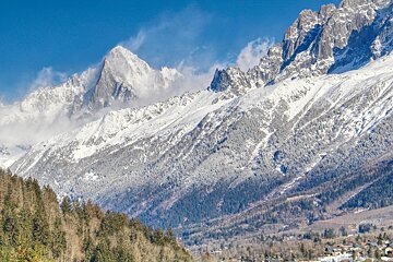 A snowy mountain range with a village in the foreground