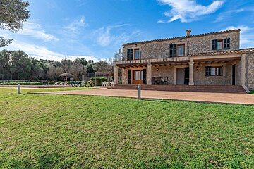 A large stone house with a large lawn in front of it