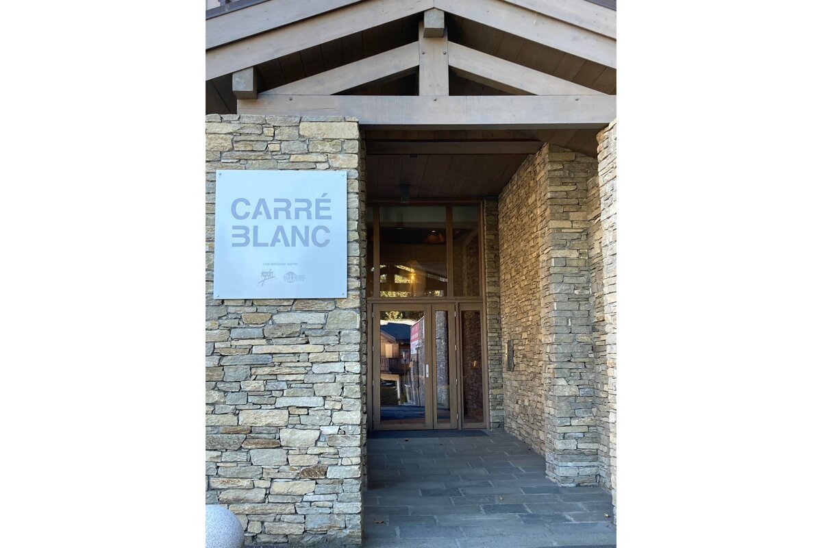 A stone building with a sign that says carre blanc