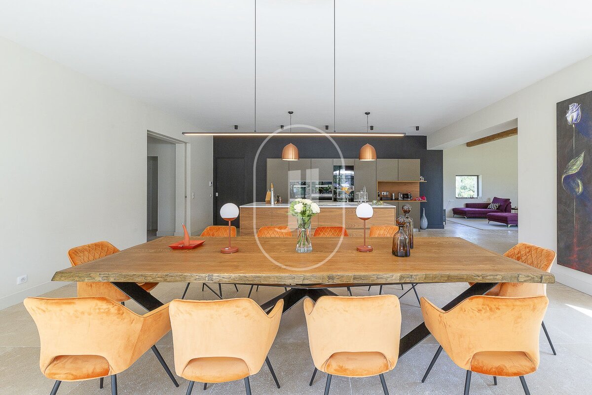 A dining room with a wooden table and orange chairs