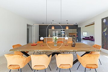A dining room with a wooden table and orange chairs