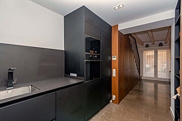A kitchen with black cabinets a sink and a microwave
