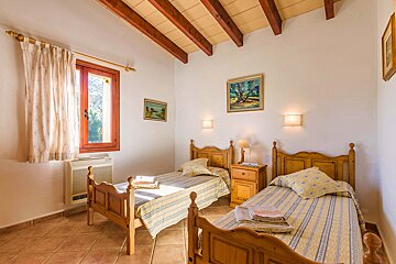 A bedroom with two beds and two paintings on the wall