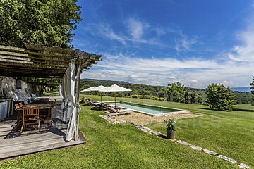 A large swimming pool is surrounded by chairs and umbrellas