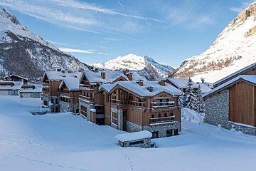 Snow covered buildings with a mountain in the background