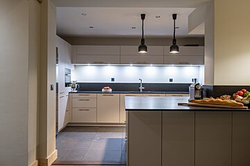 A kitchen with white cabinets and black counter tops