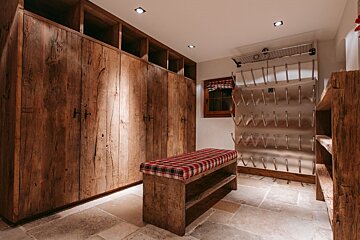 A room with wooden cabinets and a bench with a plaid cushion