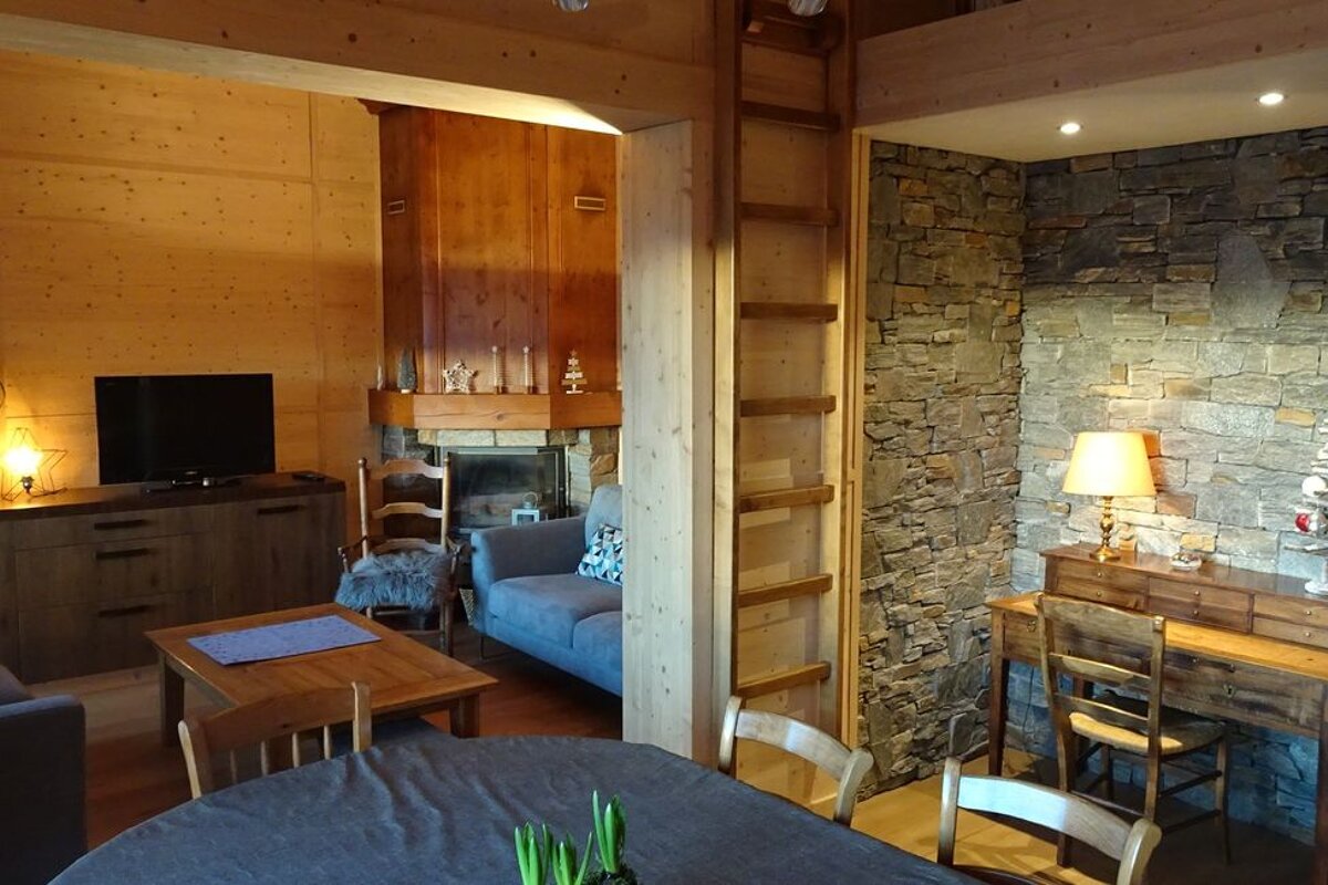 A living room with a table and chairs and a fireplace