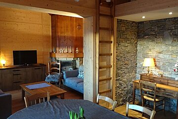 A living room with a table and chairs and a fireplace