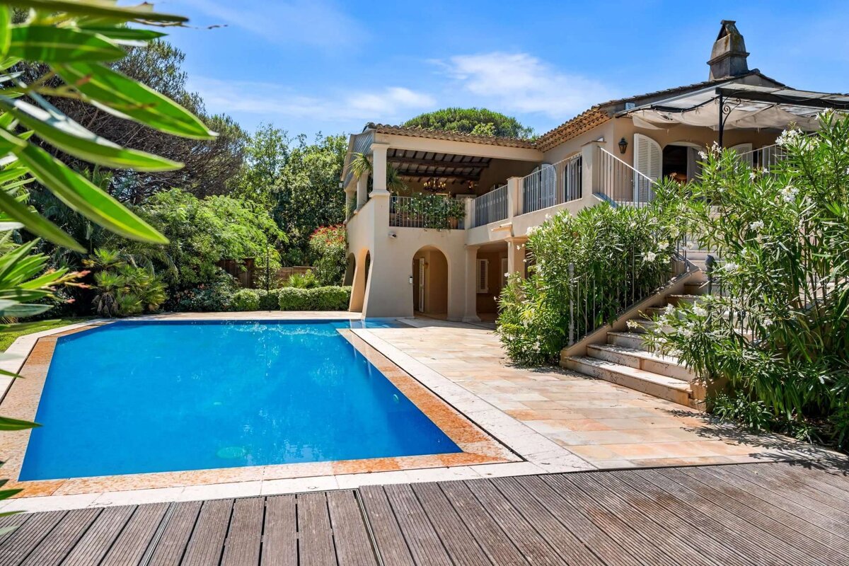 A large house with a large swimming pool in front of it