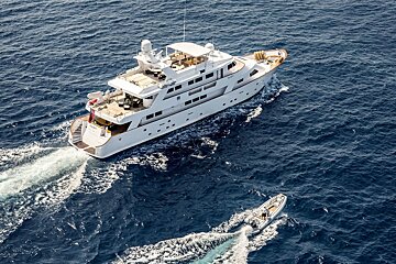 A large white yacht is floating in the ocean