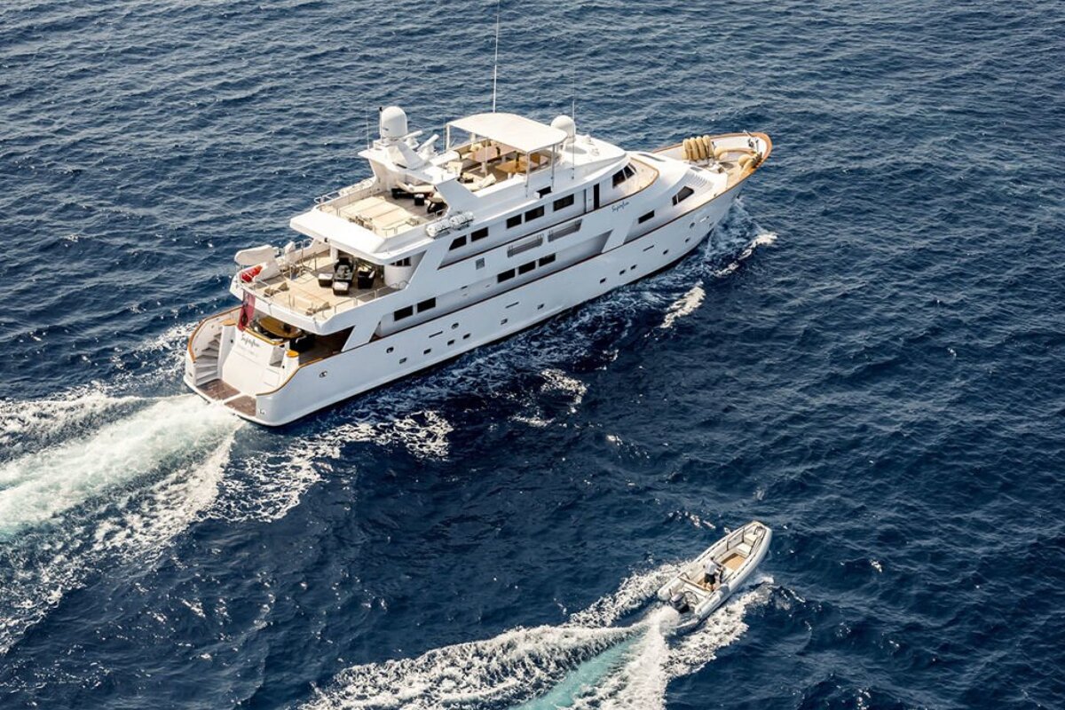 A large white yacht is floating in the ocean