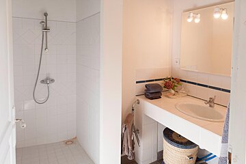 A bathroom with a sink and a walk in shower
