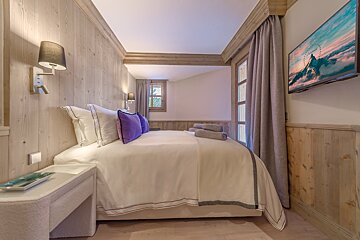 A bedroom with a large bed and a flat screen tv