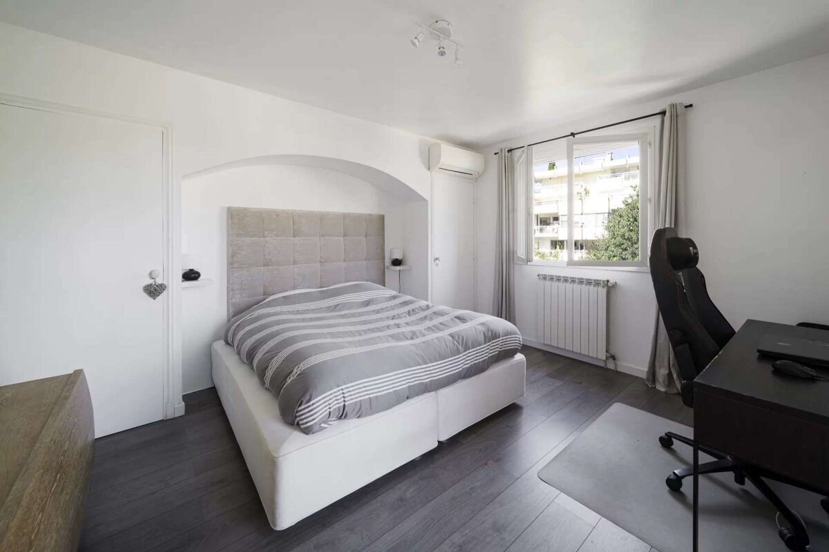 A bedroom with a bed a desk and a chair