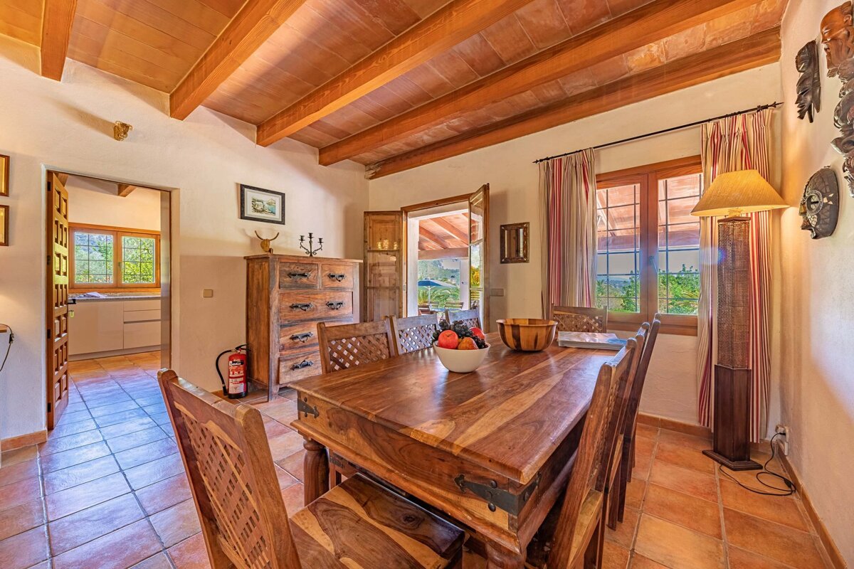 A dining room table with a bowl of fruit on it