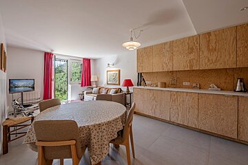 A living room with a table and chairs and a flat screen tv
