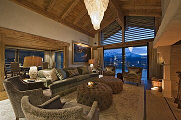 A living room with a couch chairs and ottomans