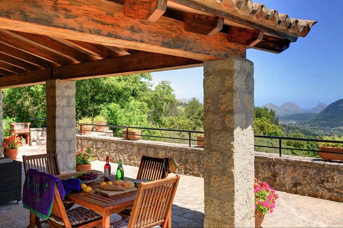 A patio with a table and chairs and a bottle of wine