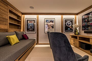 A movie poster for jaws hangs on a wall above a couch