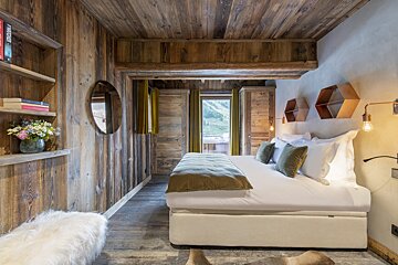 A bedroom with a bed and a bookshelf with a book titled fireside