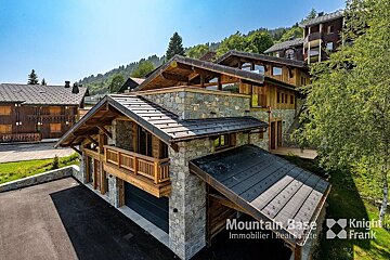 A mountain base real estate logo is on the side of a building
