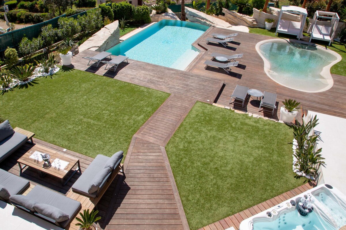 A large backyard with a swimming pool and a hot tub