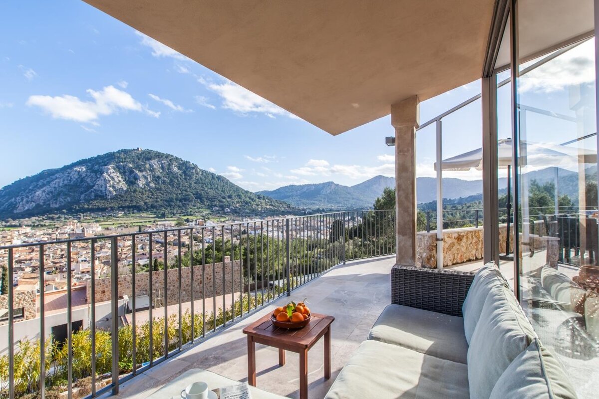 A balcony with a view of mountains and a city