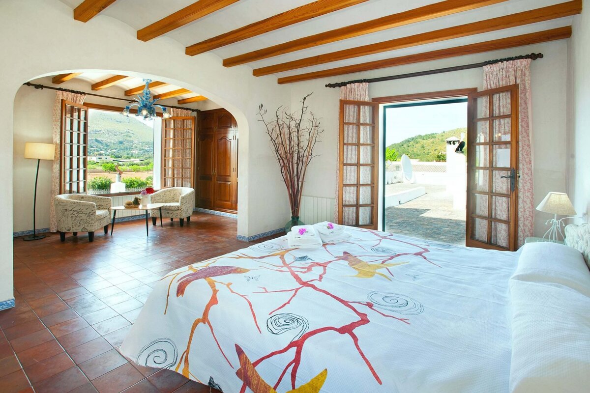 A bedroom with a king size bed and a balcony